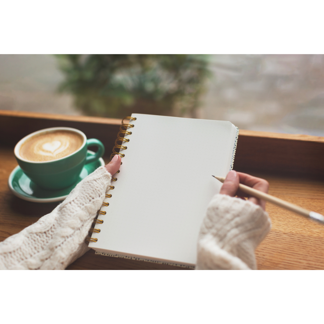 Notizen Ein leeres Notizbuch, eine Hand hält einen Bleistift in der Hand, daneben eine grüne Kaffeetasse mit Herz.