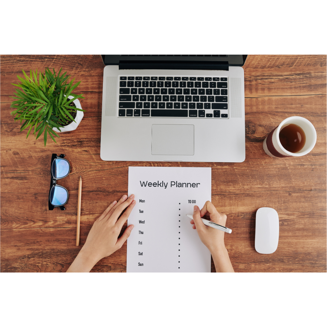 Zeitmanagement Ein offener Laptop, davor liegt ein Weekly Planer mit todo LIste. Daneben dekorativ eine Blume; Kaffeetasse, eine Brille und ein Bleistift. Eine Hand setzt gerade zum Schreiben an.