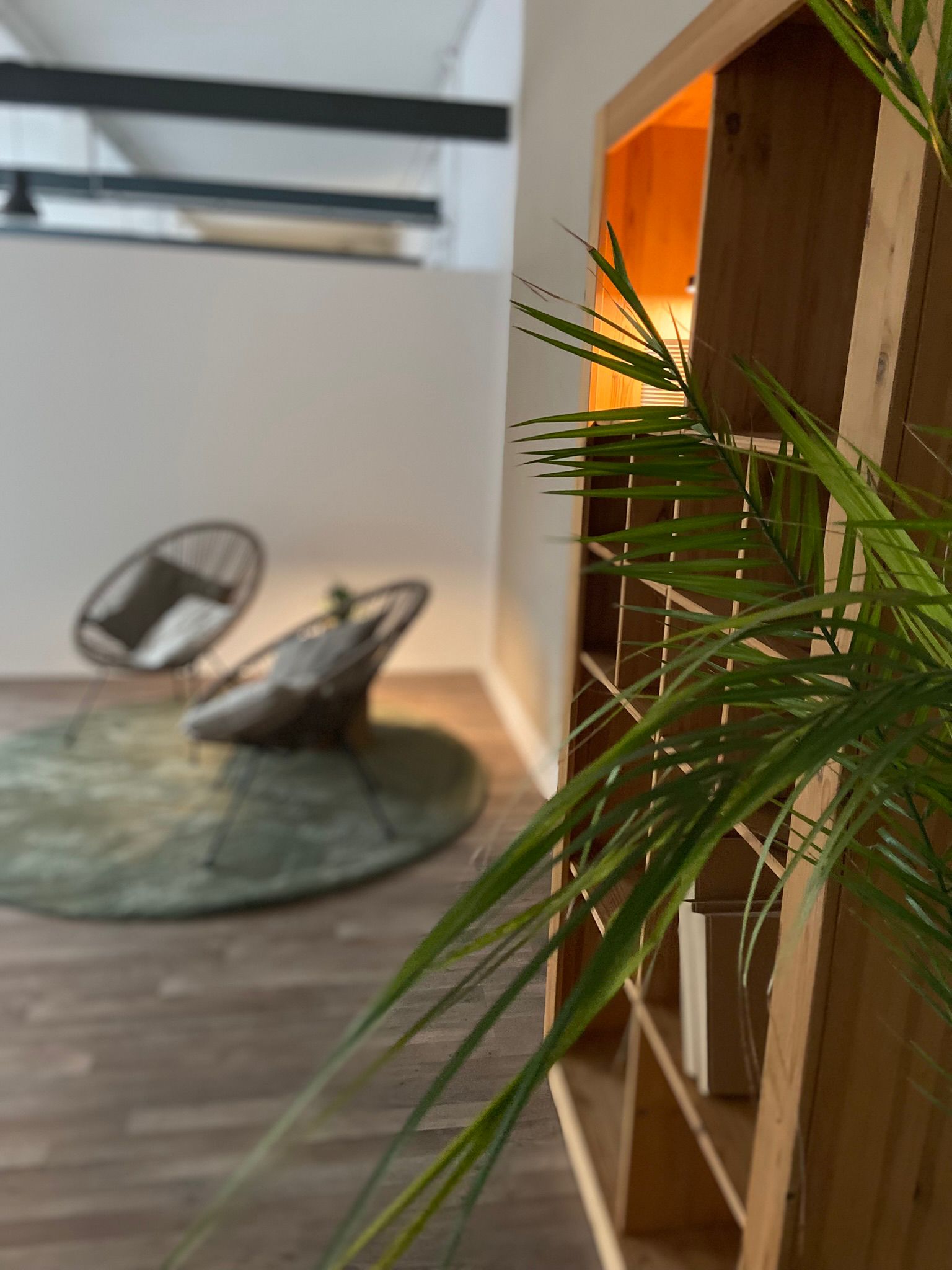 Seminarraum – Lounge Teppich, zwei Sessel mit kleinem Tisch und Blumen